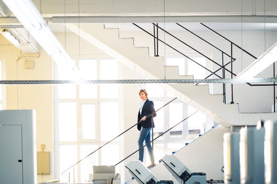 Mature entrepreneur walking on steps in workshop