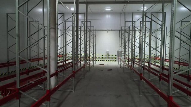 Process of assembling metal storage racks and pallets. Installing of warehouse equipment for storage. Stage of construction of shelves for warehouse. New brand logistic distribution interior room.