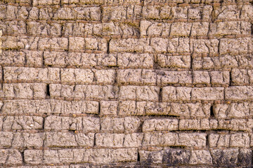 Old adobe bricks wall made of mud and straw. Useful for backgrounds and texture.