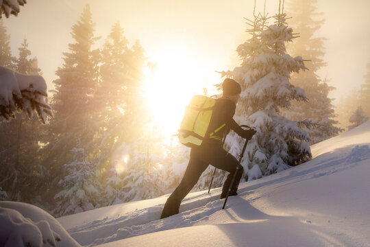 Man ski touring on snowy mountain during sunrise