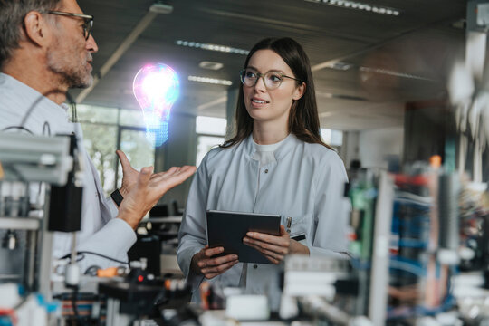 Male engineer discussing with female colleague in industry