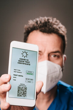 Male healthcare worker with face mask showing rapid test certificate on mobile phone