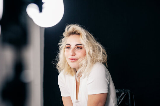 Beautiful young female model contemplating while sitting in studio