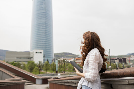 Woman standing with digital tablet in city