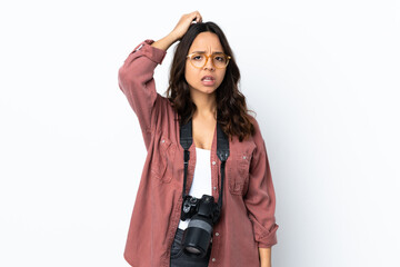 Young photographer woman over isolated white background having doubts while scratching head