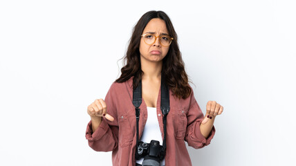 Young photographer woman over isolated white background showing thumb down with two hands