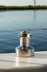 Obraz premium mooring bollard on small yacht close-up. Metal reel for rope against background of water surface