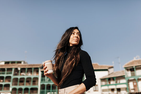 Beautiful woman with coffee cup on sunny day