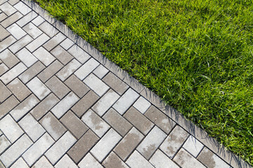 Cobbled road and green grass. Top view, background