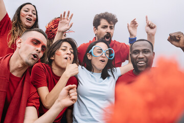 Friends with red and blue t-shirts having fun at sport championship - Young football supporters...