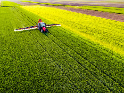 Crop sprayer sprinkling pesticide on wheat crop