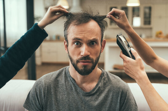 Confused man having haircut at home