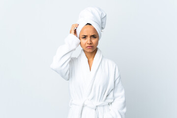 Young woman in bathrobe over isolated white background having doubts