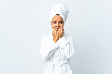 Young woman in bathrobe over isolated white background nervous and scared putting hands to mouth