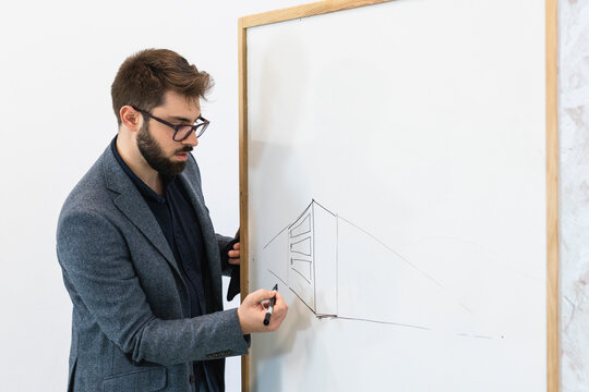 Young businessman drawing diagram on whiteboard