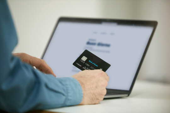 Man using paying through credit card while online shopping on laptop in office