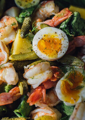 salad with eggs, shrimp, prawns, potatoes, pickles, fennel, lettuce