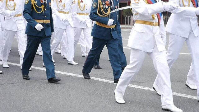 Servicemen walking at the parade in slow motion in white uniforms, clothes. Military march