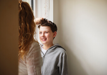 Mother measuring height of son at home