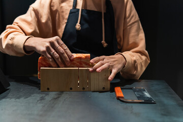 Female owner arranging soap in wooden box at supermarket