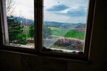 Bulgaria and views from cute and small villages during bright day.Vintage window and dirty glass seen outside of small village view. 