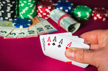 Poker cards with five of a kind combination. Close up of gambler hand takes playing cards in casino.