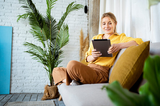 Beautiful woman with digital tablet at home - Powered by Adobe