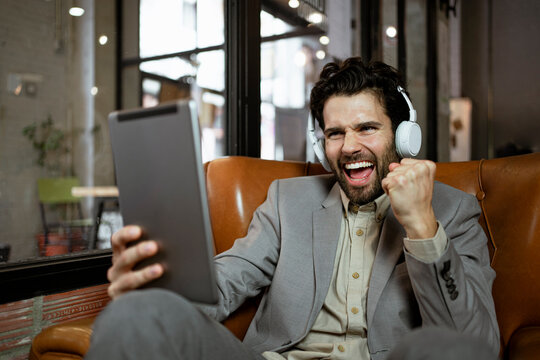Cheerful businessman gesturing while on video call through digital table at coffee shop