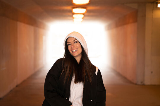 Beautiful woman wearing hooded jacket standing in underground