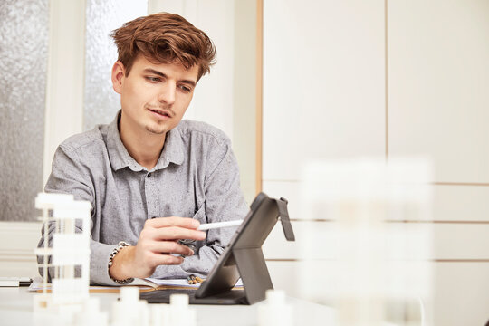 Young male architect working over digital tablet at table