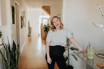 Cheerful woman standing by table at home