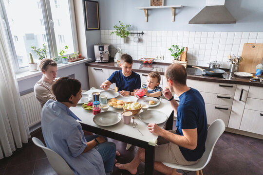 Happy family eating at dining table in kitchen at home