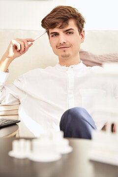 Thoughtful male architect sitting holding digitized pen at home
