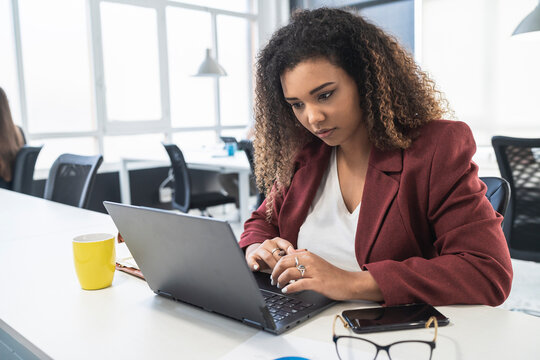 Businesswoman working on laptop at desk in office