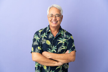 Middle age Brazilian man isolated on purple background keeping the arms crossed in frontal position