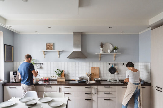 Husband and wife preparing food in kitchen at home