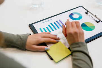 Young businesswoman working on financial report at desk in office