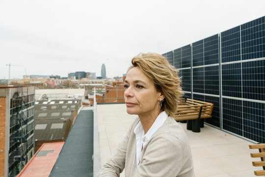 Businesswoman day dreaming while standing on office terrace