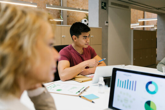 Male and female entrepreneurs discussing during meeting in coworking office