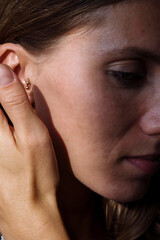 Fototapeta premium Close up of a woman’s ear with multiple earrings