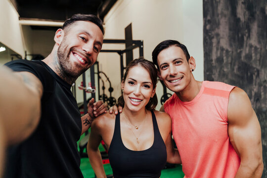 Athletes smiling while taking selfie in gym