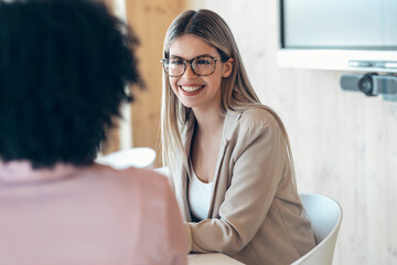 Smiling female professional with coworker in office