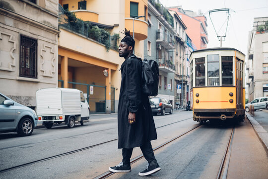 Young man looking away while walking on tramway