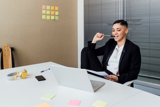 Female entrepreneur looking at laptop while sitting at office