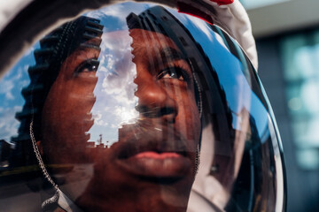 Male astronaut wearing space helmet looking up