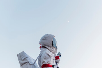 Male astronaut standing while pointing at sky