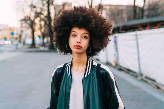 Young woman staring while standing on road