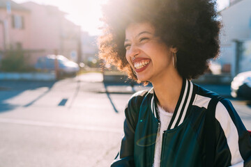 Curly hair woman smiling while looking away