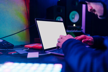 Male hacker analyzing data on laptop at home