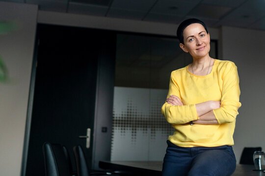 Confident businesswoman with arms crossed at office